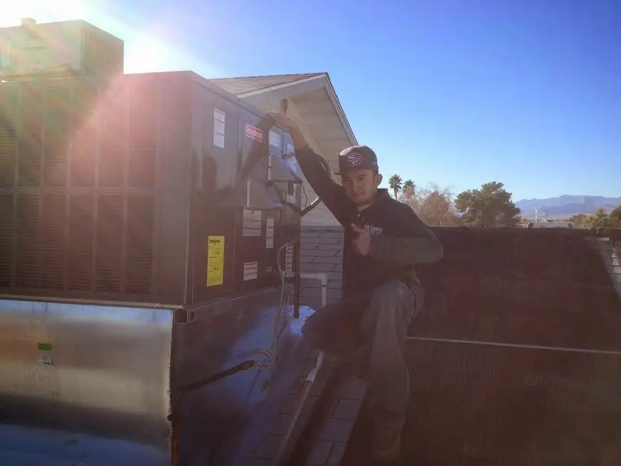 HVAC technician performing Air Duct Cleaning on a rooftop unit in San Bernardino
